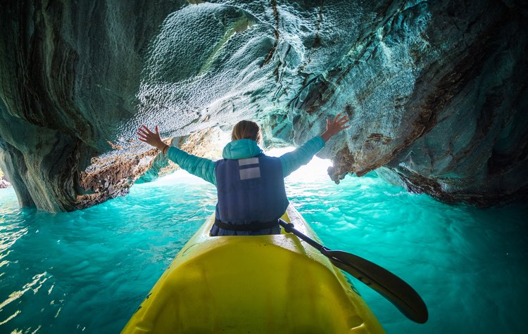 Woman explores caves with kayak